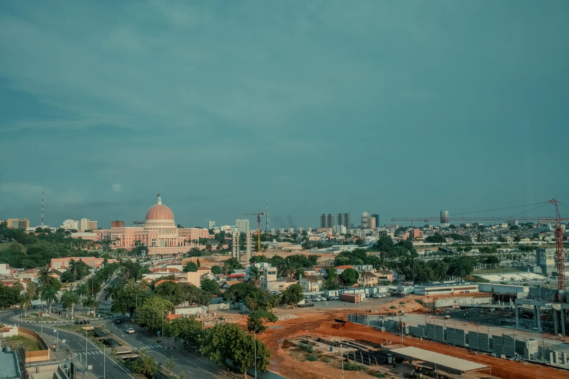 A cityscape is under a cloudy blue sky.