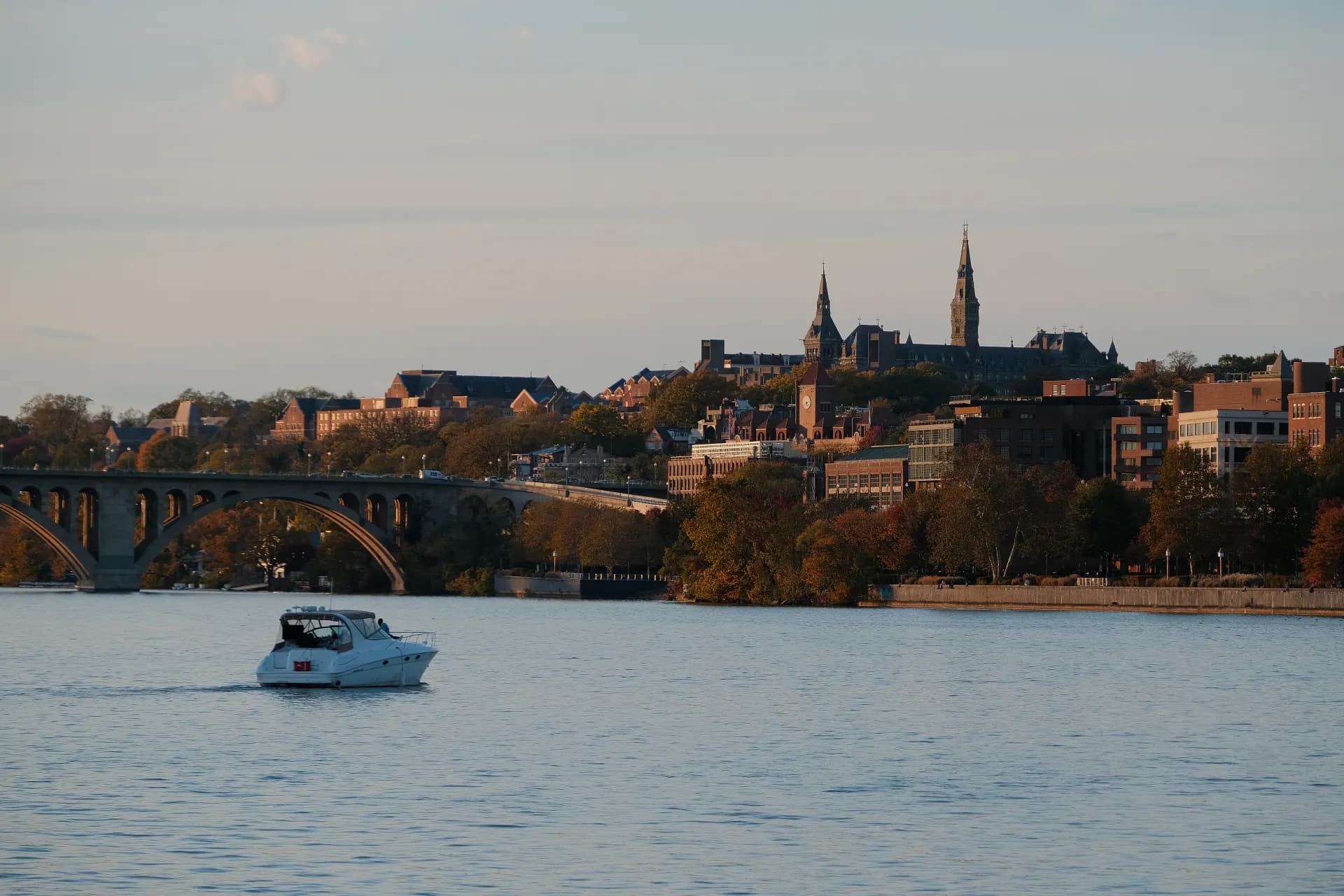 Boat on water with city skyline and bridge.