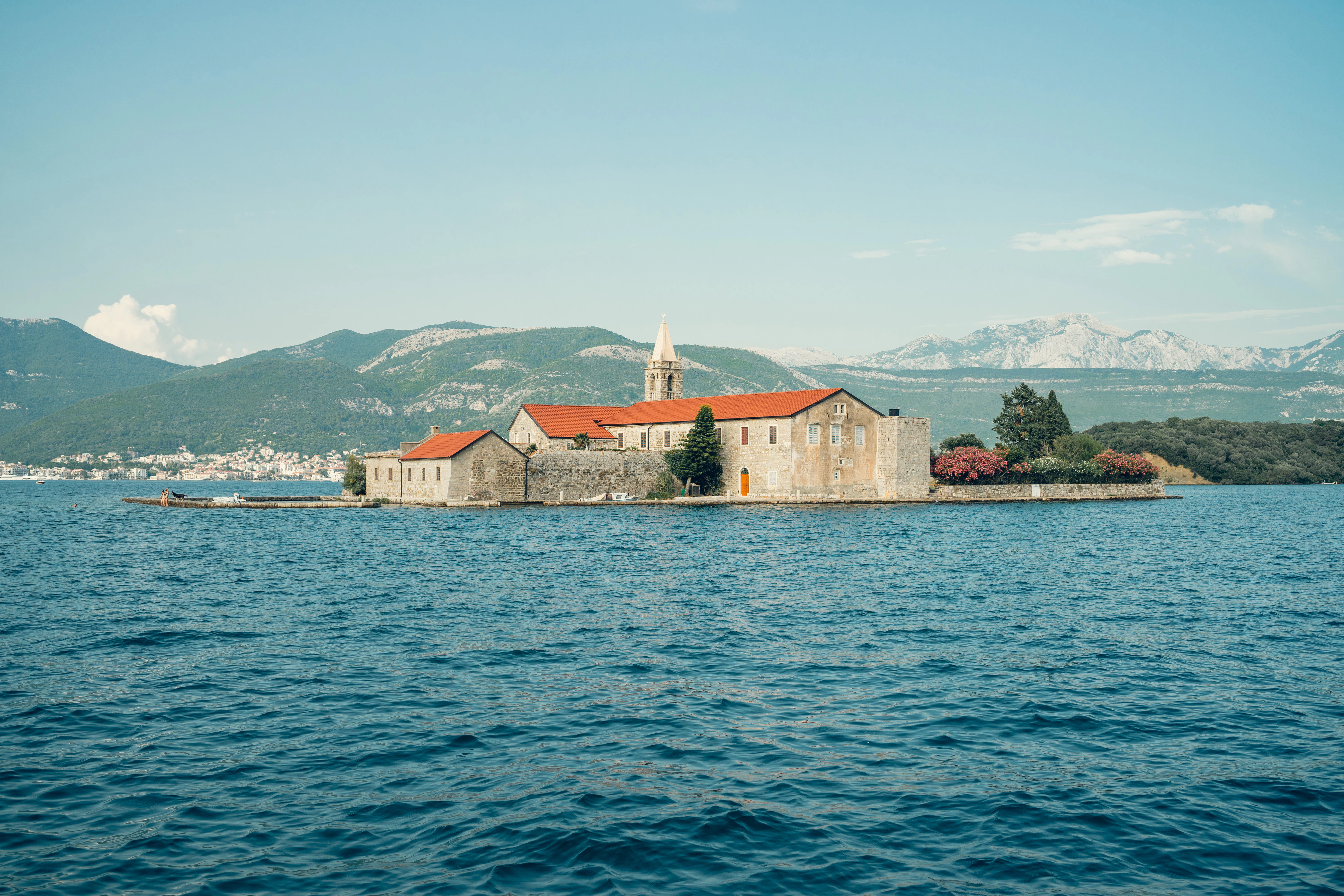 Island monastery with bell tower on blue water